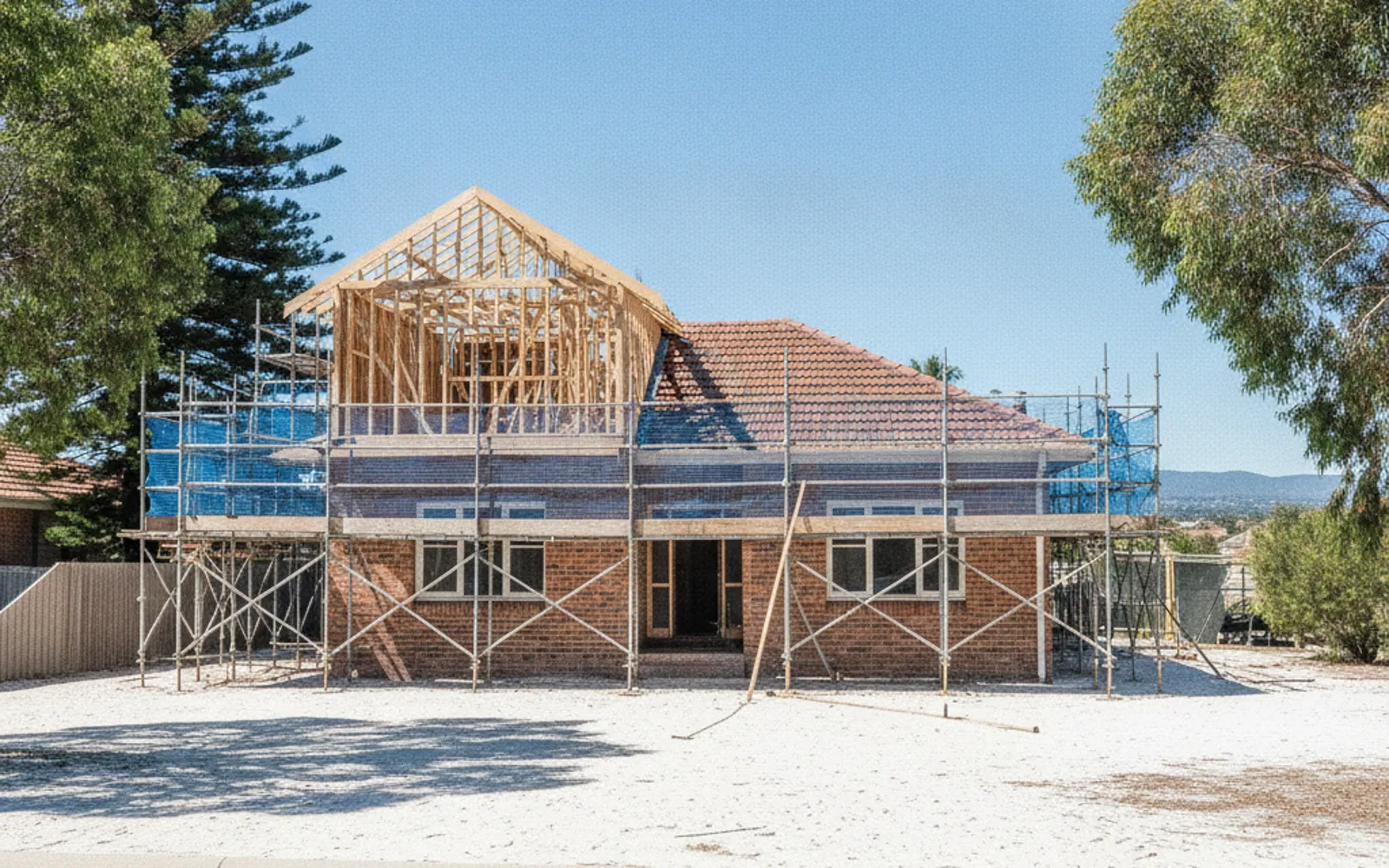 Timber frame of a second-storey addition going up on a single-storey brick house
